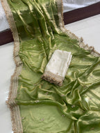 Green fabric with gold border and white cloth on a white surface
