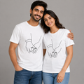 Man and woman wearing matching white t-shirts with a design of hands holding rings on a gray background