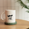 White mug with mustache design and 'MR.' text on a wooden table