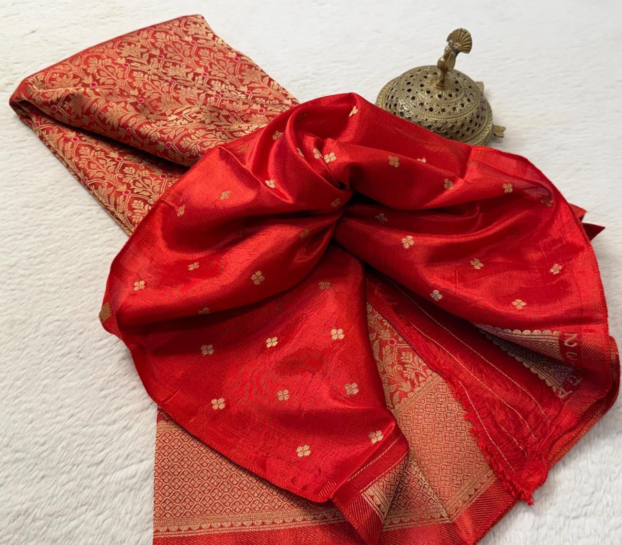 Red saree with gold patterns on a white background