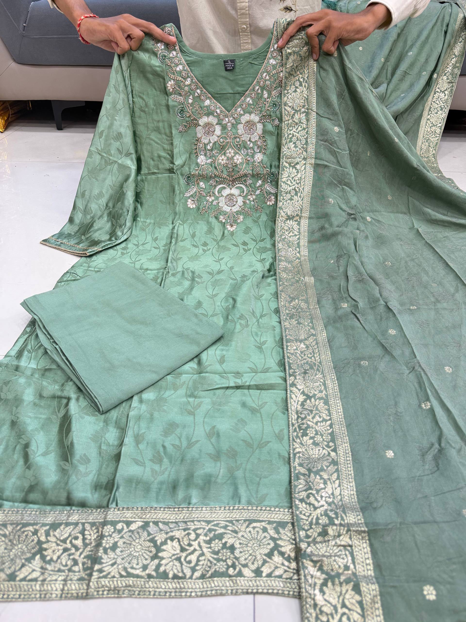 Green embroidered traditional outfit with a plain background