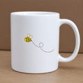 White mug with a bee design on a wooden surface and brown background