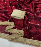 Red fabric with gold embroidery and a folded beige fabric on top