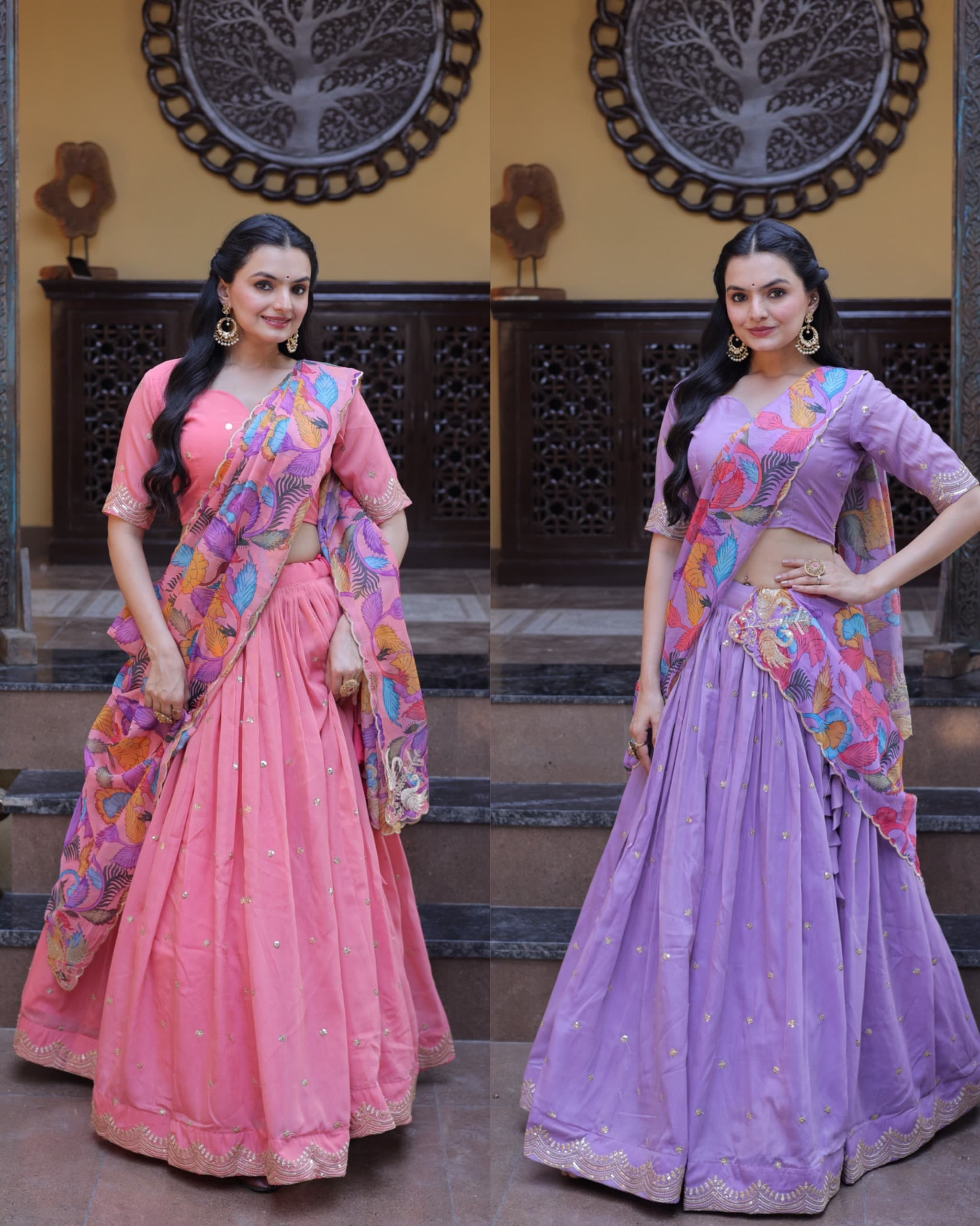 Two women in colorful sarees standing in a decorative indoor setting.