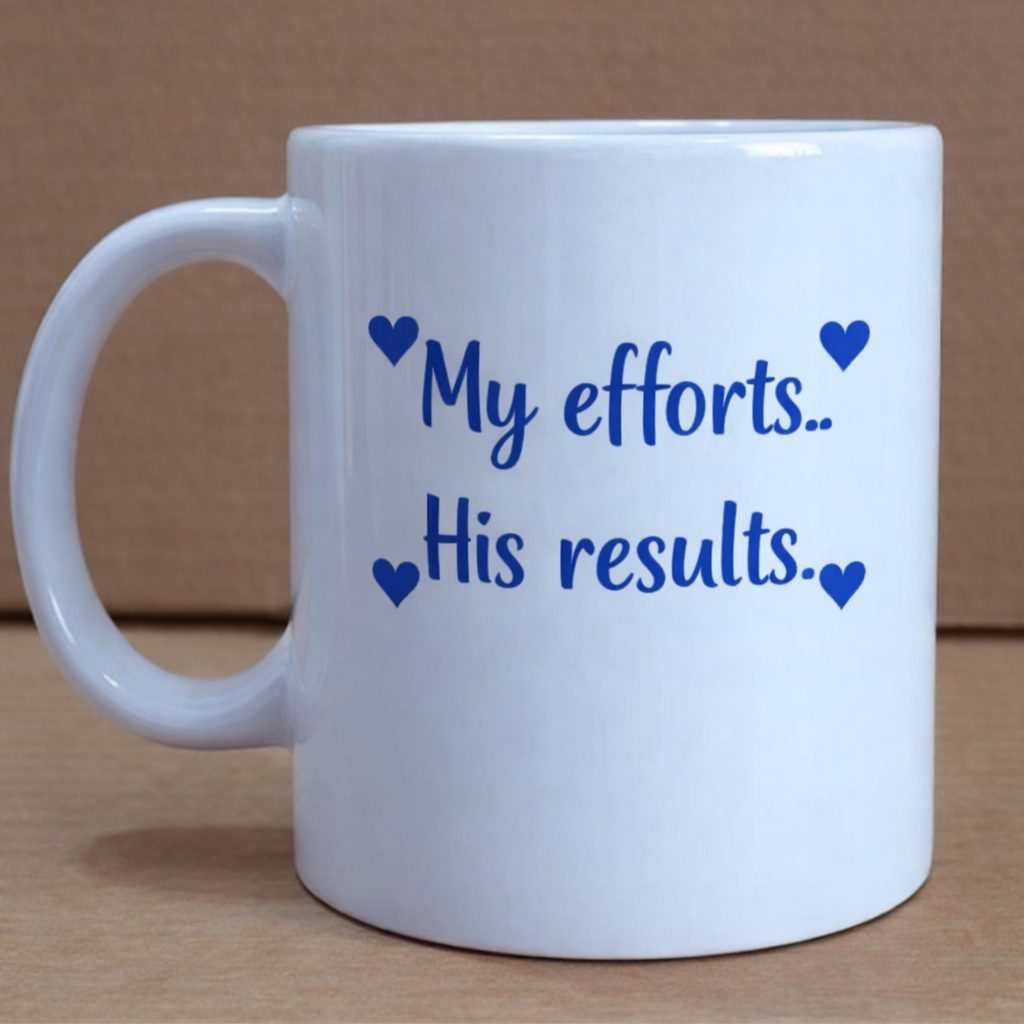 White mug with blue text 'My efforts.. His results.' on a brown background